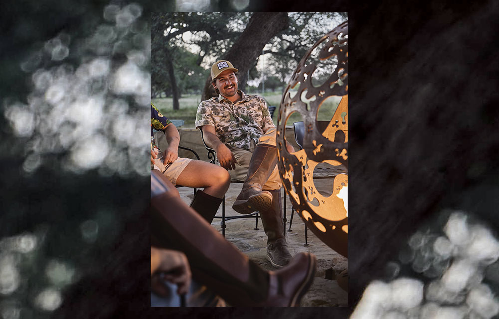 A man wearing Chippewa snake boots by a camp fire.